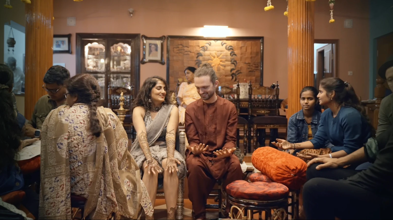 A couple sharing a smile during their wedding celebration, surrounded by family
